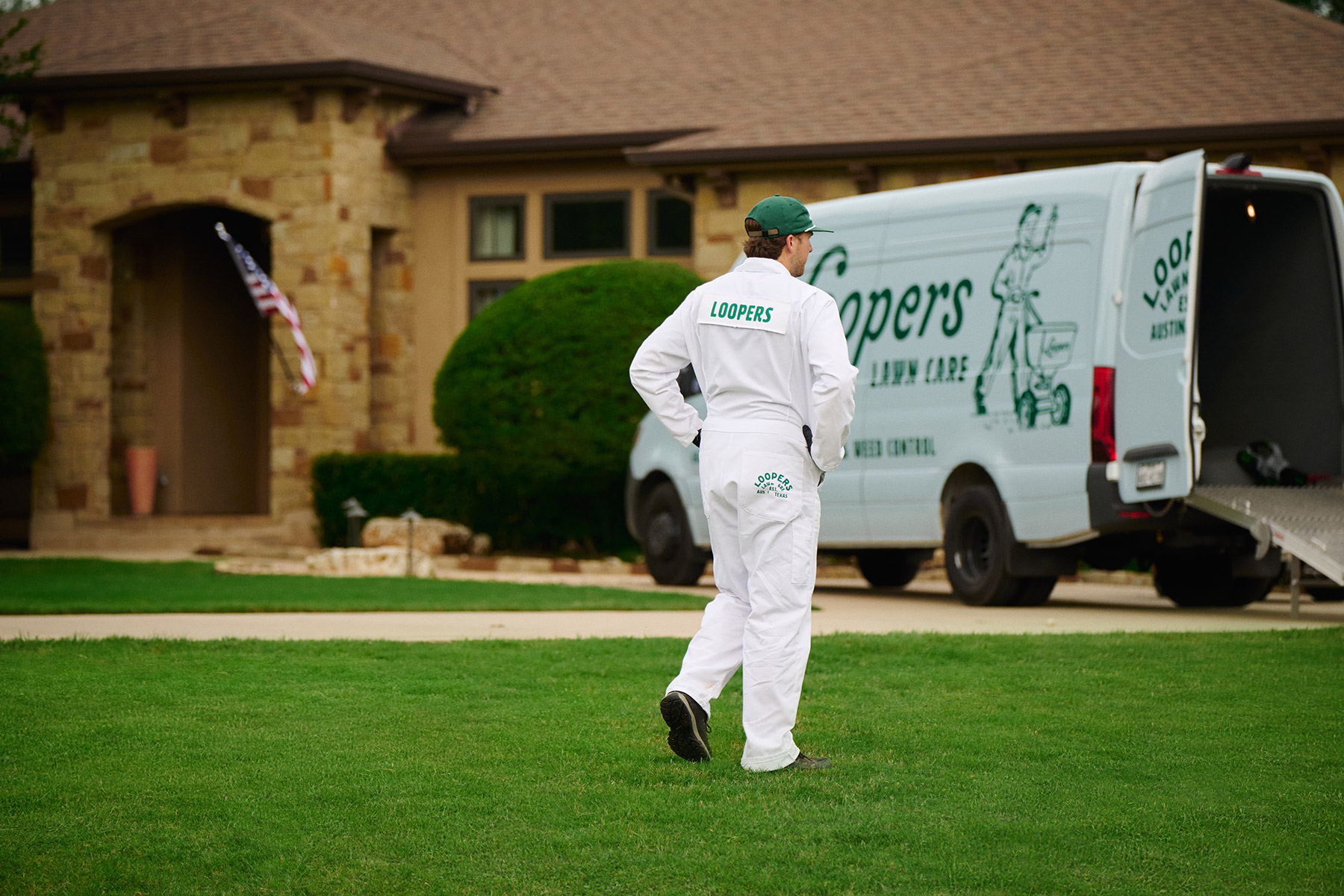 lawn care tech inspecting grass van
