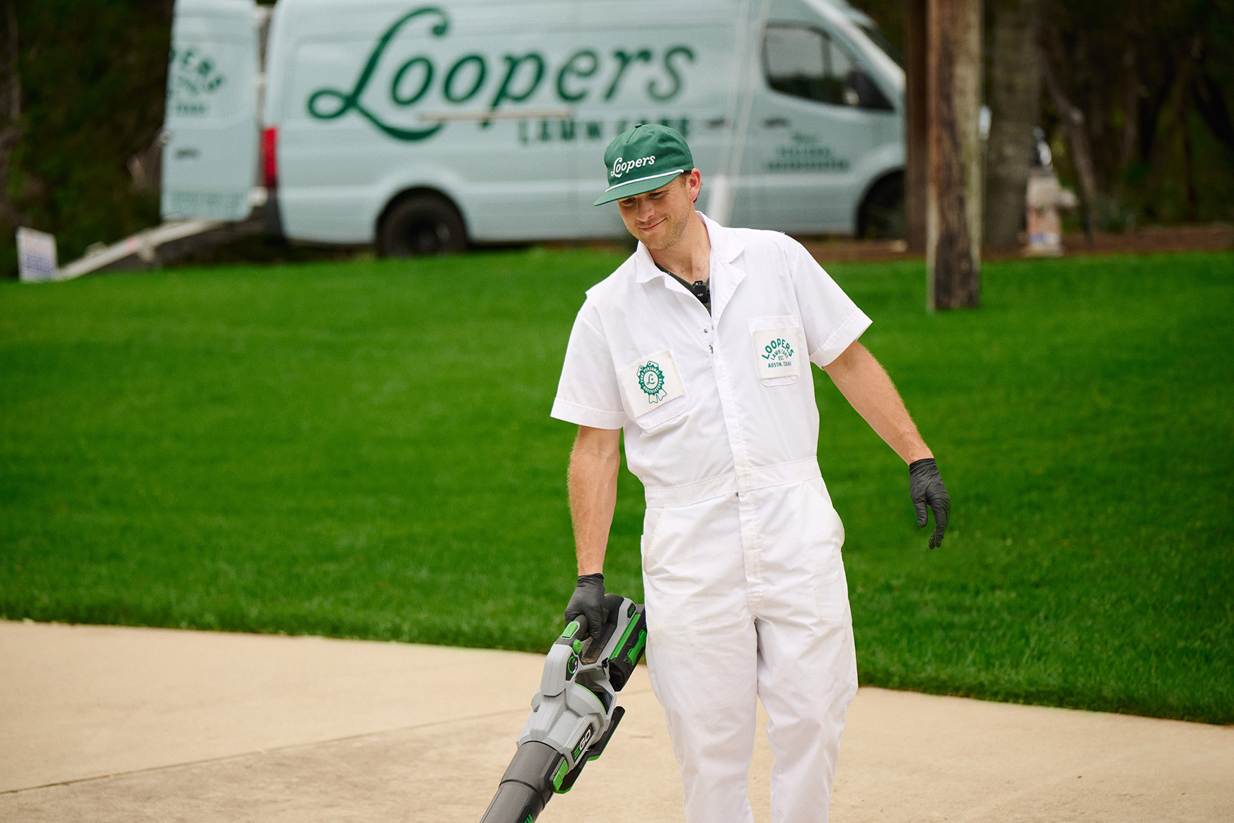 lawn care tech smiling leaf blower cleaning up
